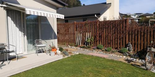 a backyard with a fence and a chair on a patio at Grampians B&B in Nelson