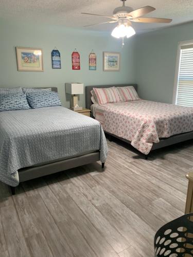 a bedroom with two beds and a ceiling fan at Sea Club Condo #37 in Clearwater Beach