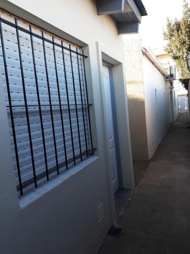 a building with a gate on the side of it at San Cayetano Departamento por dia con cochera gratis in Bahía Blanca