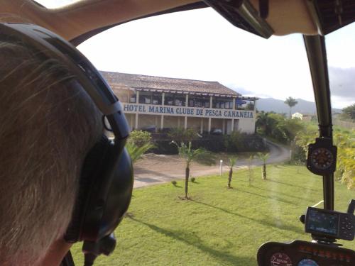 a person in a helicopter looking out at a building at Hotel Marina Clube de Pesca in Cananéia