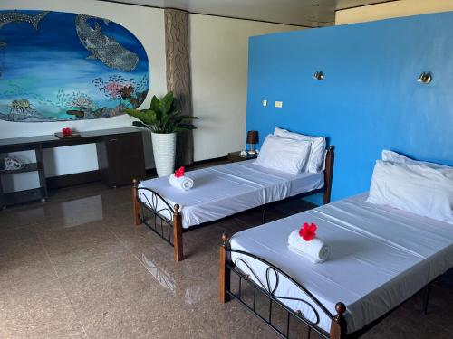 2 letti in una camera con pareti blu di Cabilao Sunset Dive & Beach Resort a Loon