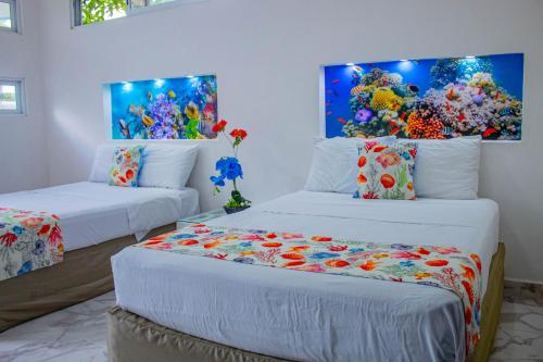 duas camas num quarto com um quarto subaquático em Las Fridas em Bacalar