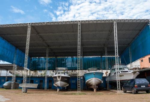 a group of boats are parked under a building at Hotel Marina Clube de Pesca in Cananéia