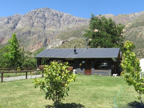 a cabin with a mountain in the background at Cabañas Emporio de la Meme in San José de Maipo