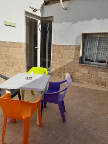 a table and colorful chairs in a room at Piso La Buganvilla in Bailén