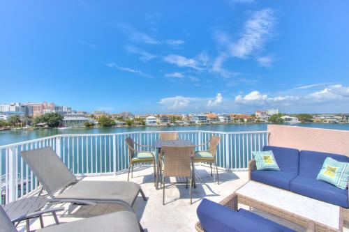 a balcony with a blue couch and chairs and the water at Bayway Luxury Suites 1 townhouse in Clearwater Beach