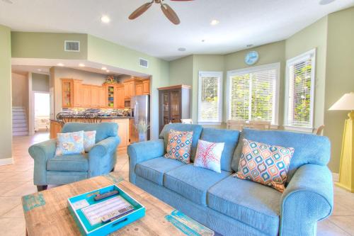 a living room with two blue couches and a table at Bayway Luxury Suites 1 townhouse in Clearwater Beach