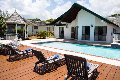 una terraza con sillas y una piscina en Sol Mar Villa en Duncans