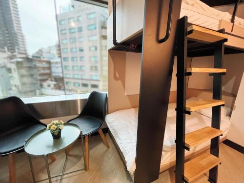a room with a bunk bed and two chairs and a table at Formosa 101 Taipei Main Branch in Taipei