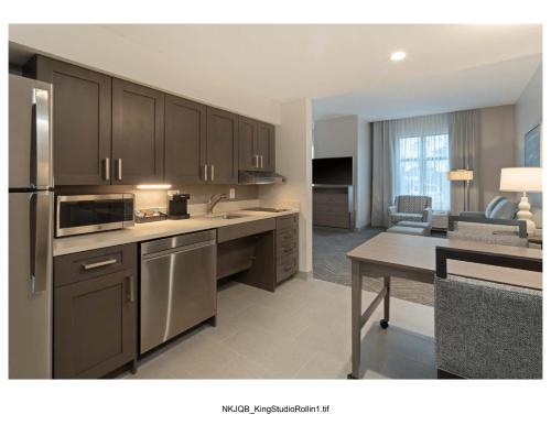 a kitchen with stainless steel appliances and a living room at Homewood Suites By Hilton Panama City Beach, Fl in Panama City Beach
