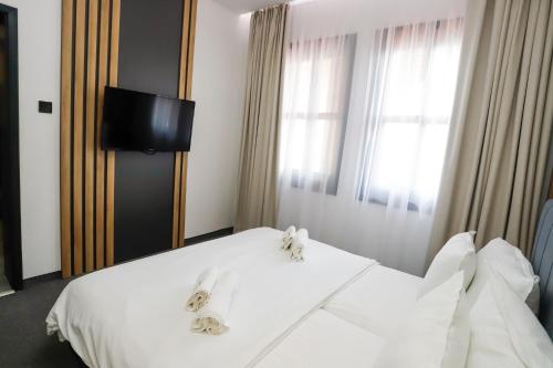 a bedroom with a white bed and a window at Glavatarski Han in Glavatartsi