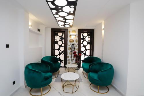 a room with four green chairs and a table at Glavatarski Han in Glavatartsi