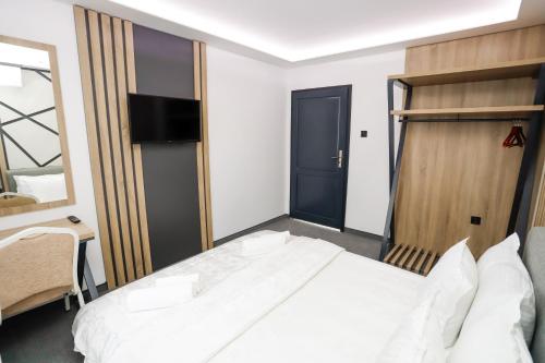 a bedroom with a bed and a television in it at Glavatarski Han in Glavatartsi