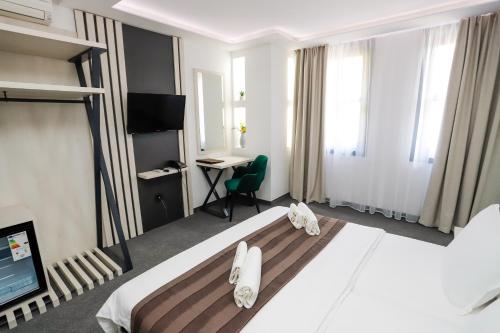 a hotel room with a large bed and a desk at Glavatarski Han in Glavatartsi