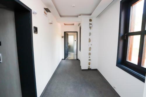 an empty hallway with a door and a window at Glavatarski Han in Glavatartsi