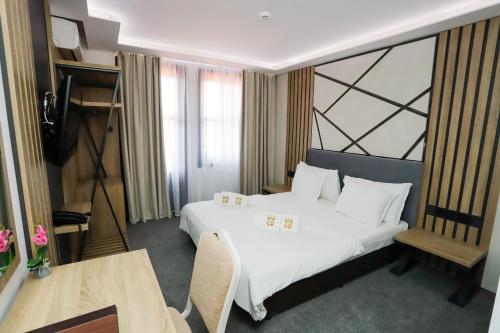 a hotel room with a large bed and a television at Glavatarski Han in Glavatartsi
