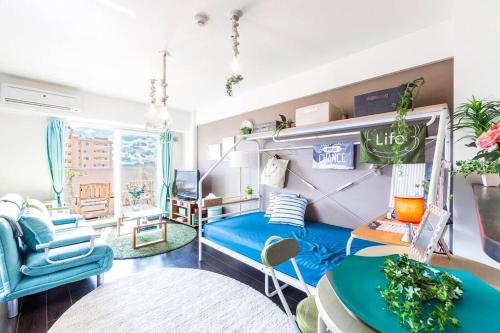 a room with a blue bed and a table and chairs at SWEET in Sapporo
