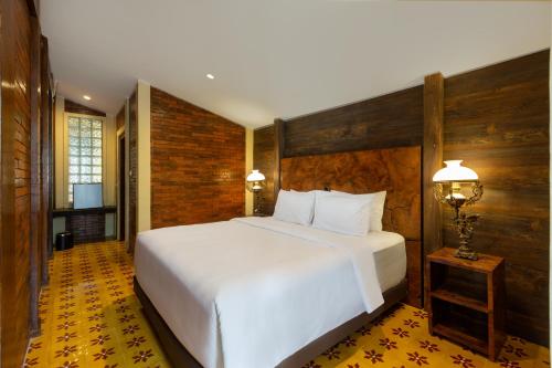Bale Devata Resort في سليمان: غرفة نوم مع سرير أبيض كبير في غرفة