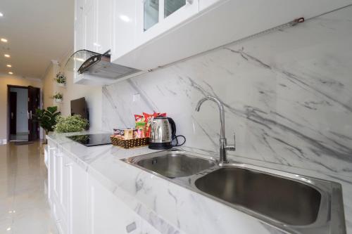 a kitchen with a sink and white marble counter top at Mon Homestay Hạ Long in Ha Long