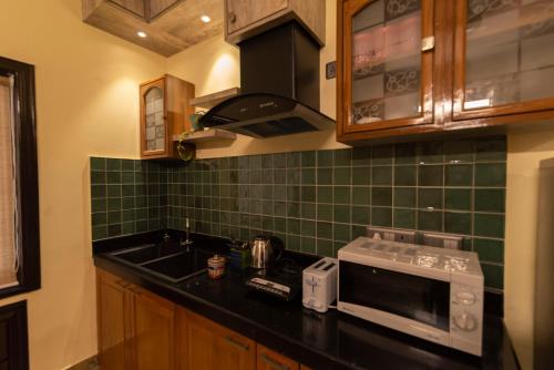 a kitchen with a sink and a microwave at J's Nest in Kolkata