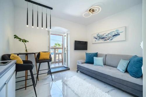 ein Wohnzimmer mit einem Sofa und einem Tisch in der Unterkunft Apartment Vin - sea promenade in Supetar
