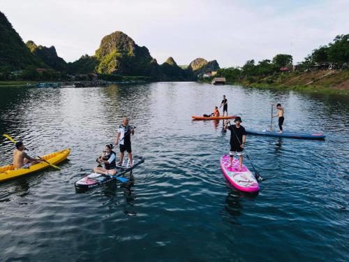 a group of people on paddle boards in the water at Lucky Homes in Phong Nha