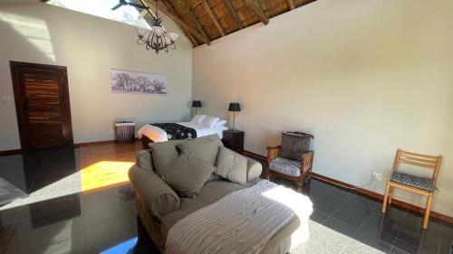 a living room with a couch and a bed at The Vaal Guesthouse in Oranjeville