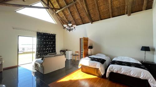 a bedroom with two beds and a chandelier at The Vaal Guesthouse in Oranjeville