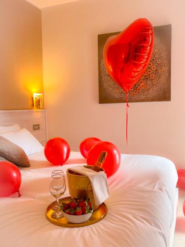 a bed with red balloons and a bowl of fruit and a wine glass at La Ripa Camere Vernazza in Vernazza