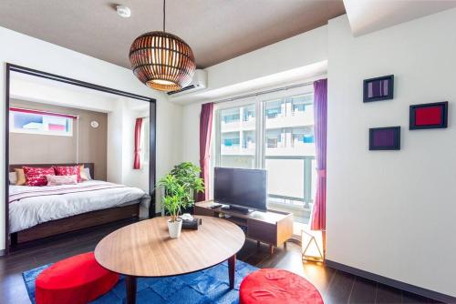 a bedroom with a bed and a table and a tv at EDEN in Sapporo