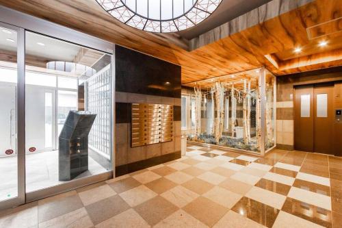 a lobby with a fireplace and a large window at EDEN in Sapporo
