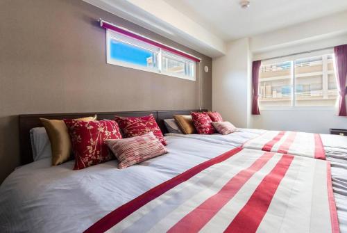 a bedroom with a large bed with red and white pillows at EDEN in Sapporo
