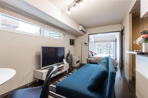 a living room with a blue couch and a tv at SPARKLE in Sapporo