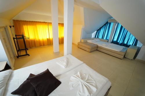 a large white bed in a room with windows at Complex Marinn Costinesti in Costinesti