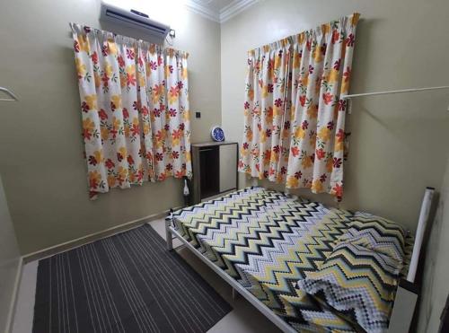 um quarto com cortinas e uma cama num quarto em Desa Hana Homestay em Kuala Terengganu
