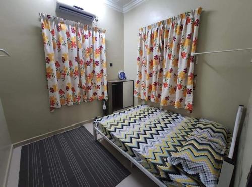 a bedroom with curtains and a bed in a room at Desa Hana Homestay in Kuala Terengganu