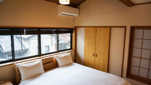 a bedroom with a bed with two pillows and a window at Machiya no Yado / Vacation STAY 24402 in Kyoto