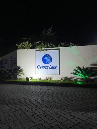 a sign on a wall with a sign for a company at Golden Lake Apart Hotel Arraial do Cabo in Arraial do Cabo
