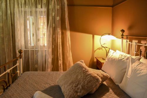 a bedroom with a bed with white pillows and a window at CASA THEOTOKI in Anemómylos