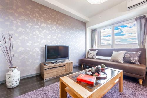 a living room with a couch and a tv at DIVA in Sapporo