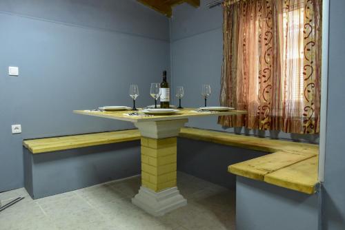 a table with wine glasses and a bottle of wine at CASA THEOTOKI in Anemómylos