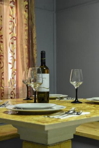 a bottle of wine and two glasses on a table at CASA THEOTOKI in Anemómylos