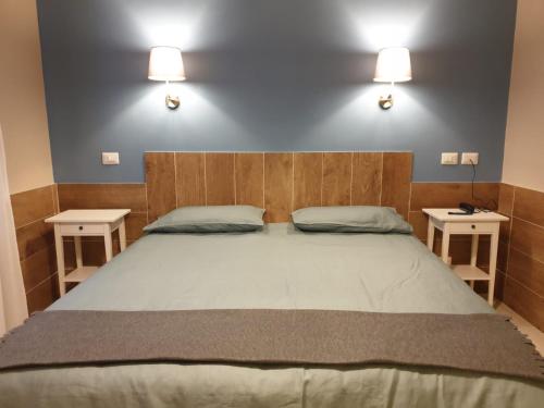 una camera da letto con un grande letto con due comodini di Hotel Il Roscio ad Attigliano
