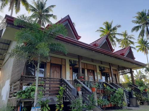 una casa con palmeras delante en Marianne's Guest House en New Agutaya