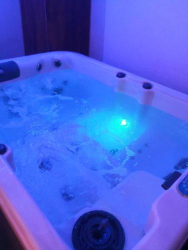 una bañera llena de agua azul en una habitación en Maison avec jacuzzi, en Saint-Mitre-les-Remparts