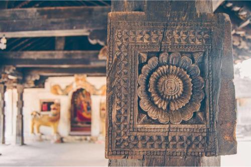 a wooden artifact with a flower on it in a building at Elegant Hotel in Kandy