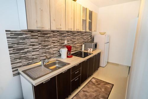 Una pequeña cocina con fregadero y refrigerador. en Seasons Primab Studio, en Brasov