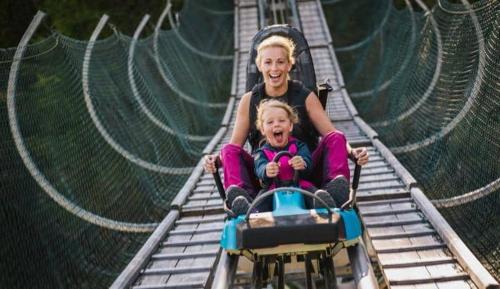 two young girls riding on a roller coaster at APARTMENT WALD - im Skigebiet Gerlitzen & Ossiacher See in Bodensdorf