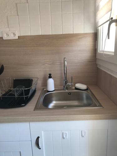 - un évier de cuisine avec un distributeur de savon dans l'établissement La ptite maison de Royan pour 4 personnes avec jardin, à Royan