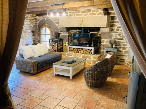 a living room with a couch and a fireplace at Maison de caractère datant de 1739 in Quistinic